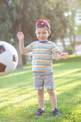 little boy playing football soccer on the field