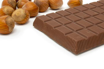 chocolate bar and hazelnuts on a white background macro photography