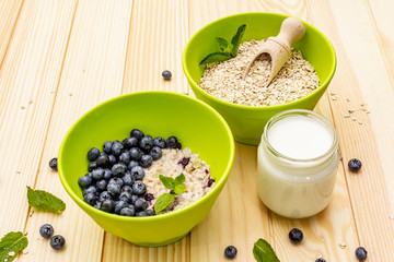 Oatmeal porridge with fresh blueberry, mint leaves and yogurt