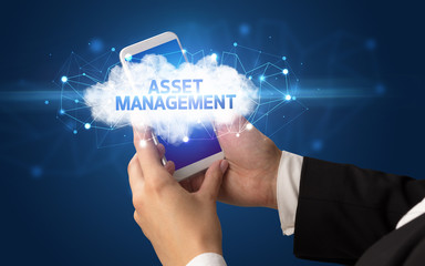 Female hand touching smartphone with ASSET MANAGEMENT inscription, cloud business concept