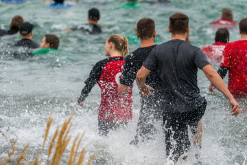 Athletes running into a lake at an obstacle course race