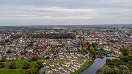An aerial view of an urban area along a park under a grey sky and white clouds