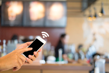 Hand use smartphone connected global via internet on cafe background