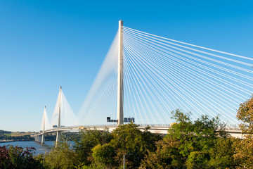 Queensferry Crossing Bridge in North Queensferry near Edinburgh. North Queensferry is located ten miles west of the center of Edinburgh in Scotland. Sunny day, blue sky in the background.