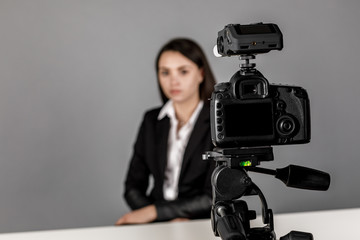 A woman makes a video for her blog using a tripod mounted digital camera
