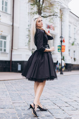 Obraz premium Fashion photosession of professional model in the city in trendy black dress. Fashion , trendy concept