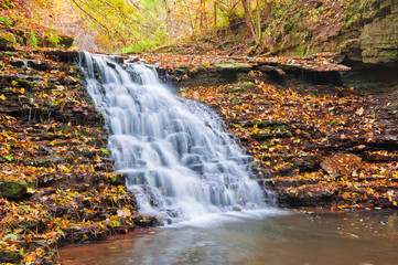 Fototapeta na wymiar Beautiful waterfall on a mountain stream in the woods