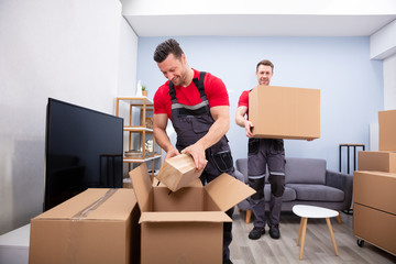 Men Loading The Cardboard Boxes During Moving