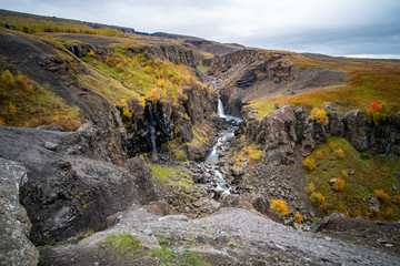 Fototapeta na wymiar hike to Hengifoss waterfall in Iceland with beautiful autumn colors