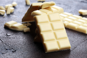 white broken chocolate and cocoa bar. Pieces of white chocolate on rustic background