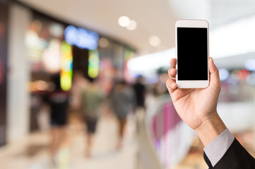 Hand hold blank smartphone on blur shopping mall background