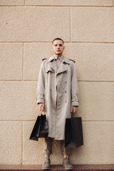 A stylish young man with bags after successful shopping on Black Friday