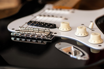 Close up of the electric guitar bridge with focus on the tome knob.