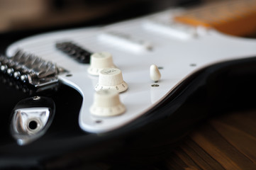 Close up of the electric guitar bridge with focus on the tome knob.