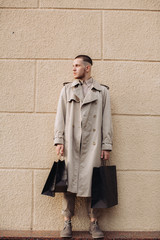 A stylish young man with bags after successful shopping on Black Friday