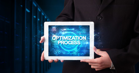 Young business person working on tablet and shows the inscription: OPTIMIZATION PROCESS, business concept