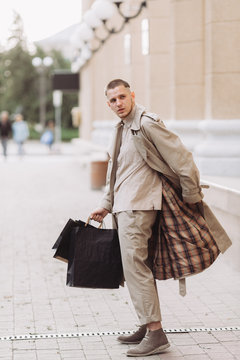 A stylish young man with bags after successful shopping on Black Friday
