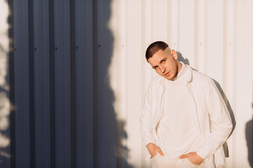 A stylish man wearing white after Black Friday shopping