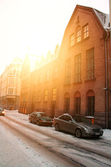 Obraz premium Winter morning cityscape of the street at sunrise. red brick house in the morning sun.