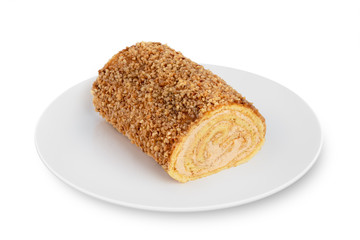 Sponge biscuit roll lies on a white plate on a white background. Biscuit roll on a white plate.