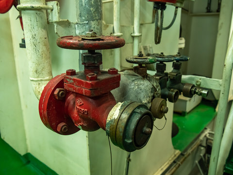 INTERNATIONAL WATERS -August 13, 2019:  Dirty fire hydrant in poor condition  the vessel engine room with several velves in background