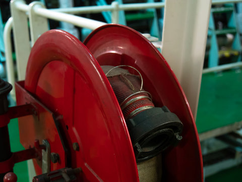 INTERNATIONAL WATERS -August 13, 2019: Close up of a dirty damaged fire hose in the vessel engine room.