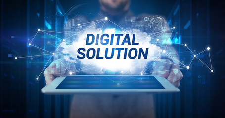 Young business person working on tablet and shows the inscription: DIGITAL SOLUTION