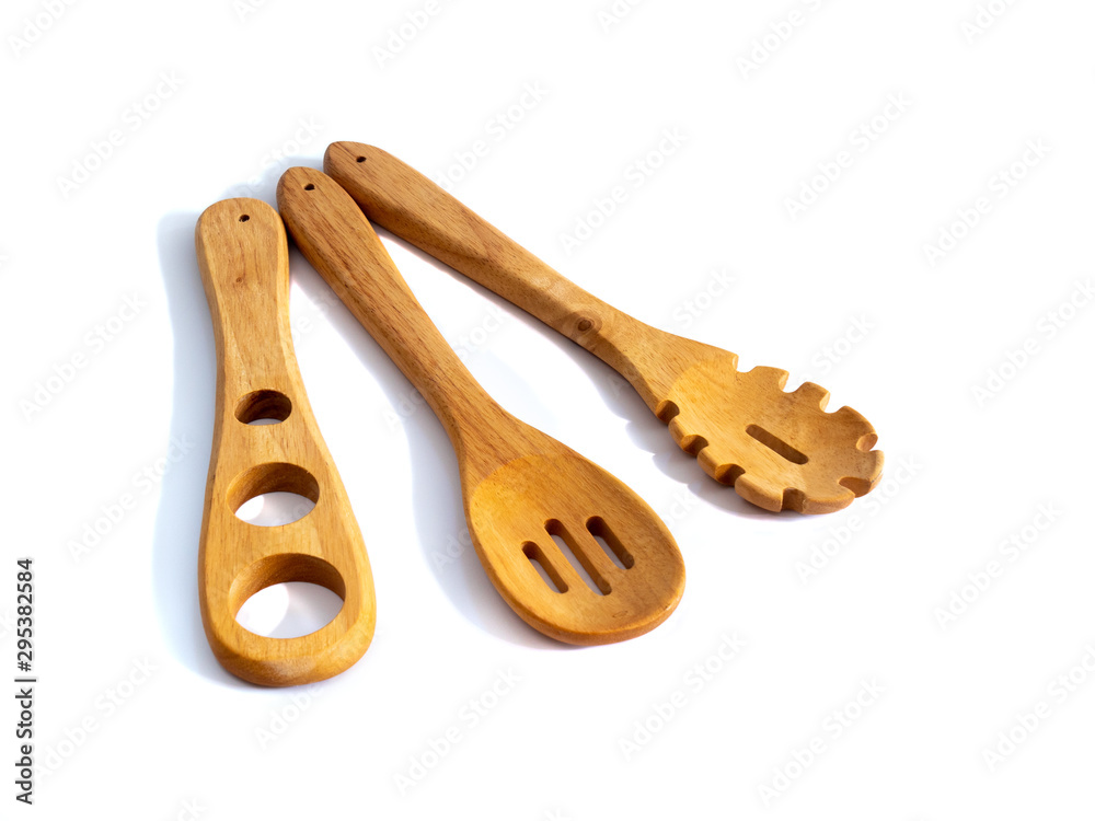 Wall mural Wooden pasta cooking utensils isolated on a white background.