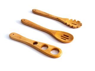 Wooden pasta cooking utensils isolated on a white background.