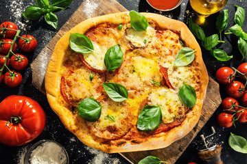 Homemade pizza with mozzarella on dark background