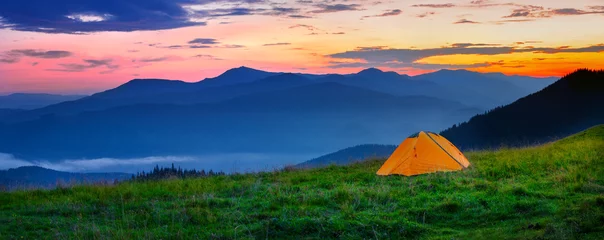 Fotobehang Oranje tent in de bergen bij zonsondergang © alexlukin