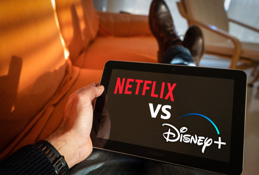 Barcelona, Spain. January 2019: Man holds a tablet with Netflix vs Disney+ application logo on screen