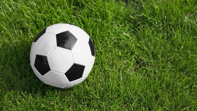 Soccer or football ball on soccer field. Space for text on the image right side