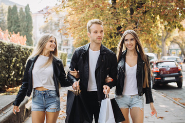 Happy friends walking after Black Friday shopping