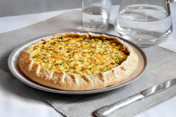 Tart with eggs and green onions on a plate