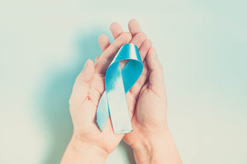 Hand holding Diabetes Awareness Blue Ribbon