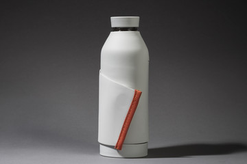 Stylish reusable plastic water bottle with silicone strap for fastening. Zero waste and sustainable lifestyle.