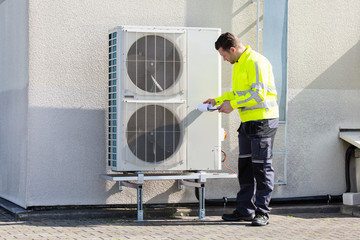 Male Technician Repairing Air Conditioner Outdoors