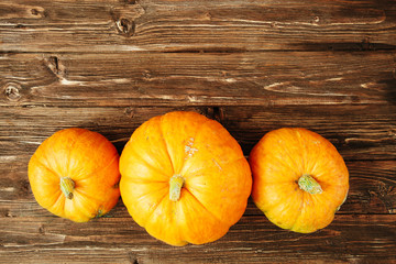 Autumn orange pumpkins over old wooden background with copy space Thanksgiving and Halloween concept. View from above. Top view. Copy space for text and design