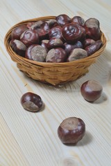 Obraz premium chestnuts in wicker cup on wooden background
