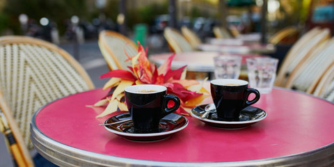 Two cups of coffee on a table of traditional outdoor cafe in Paris
