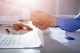 Businessmen Shake Hands With Each Other At Workplace