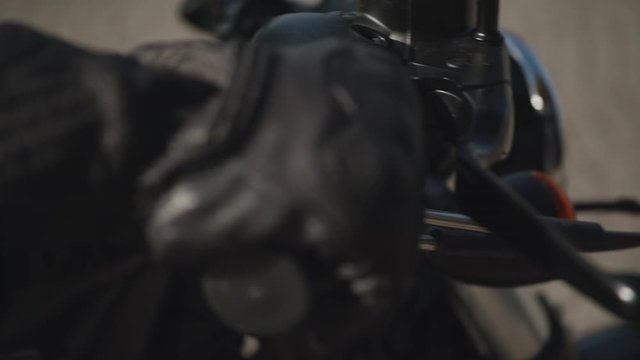Closeup of motorcyclist in a blue suit black glove on the throttle