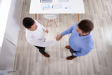 An Elevated View Of Businessmen Shaking Hands In Office