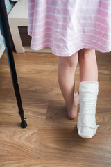 Girl with a broken leg in a cast in crutches room