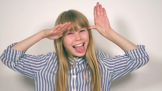 Beauty funny blonde teenage girl has a fun, jumping and laughing, showing tongue, on white background. Happy joyful school girl with long blonde hair. Emotions. Slow motion 4K UHD video