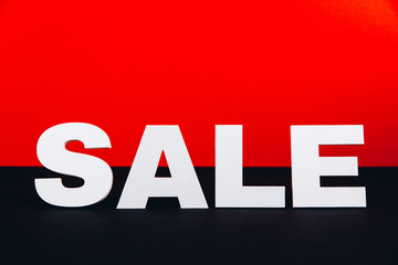 White wooden inscription sale on red and black background. Shopping and Black Friday concept
