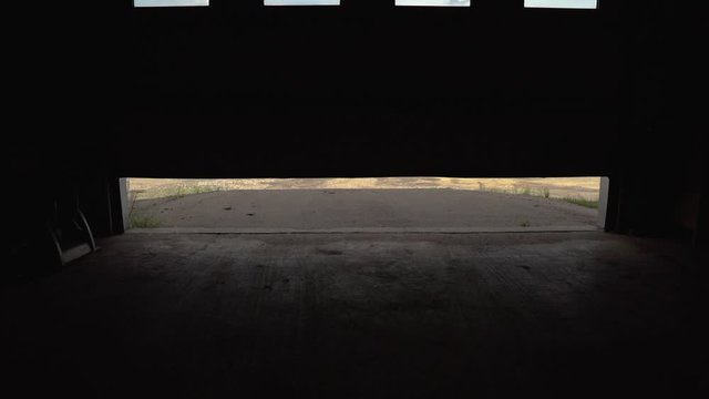 Internal shot of industrial unit opening bay doors to reveal outside, static tripod 120FPS