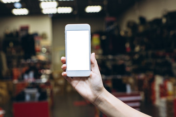 Hand using smartphone for doing business or banking or buying online on blur shopping mall background