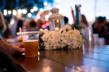 Beer on Bar Table being Held by hand